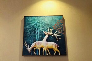 A framed artwork of a deer and tree on a wall. - Lufeng Jiali Express Hotel (Lufeng)