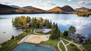 En ejendom ved søen med tennisbaner, swimmingpool og et gæstehus.