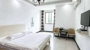 A hotel room with a bed, a desk with a chair, a television, and a window with curtains. - An Inn (Guilin Yiyuan Branch) (Guilin)