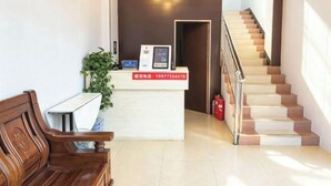 A reception area with a reception desk, a staircase, and a wooden bench. - An Inn (Guilin Yiyuan Branch) (Guilin)