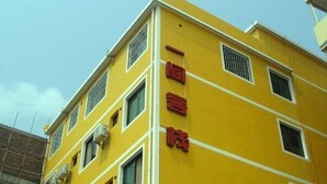 A yellow building with multiple windows and air conditioning units. - An Inn (Guilin Yiyuan Branch) (Guilin)