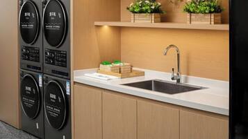 A kitchen with a built-in washing machine, a sink, and a countertop.