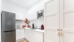 A modern kitchen with white cabinets, a stainless steel refrigerator, a microwave, and a coffee maker. - "Las Damas de Madrid 10 minutes from downtown" (Madrid)