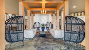 A lobby with a central seating area, a chandelier, and a patterned carpet.