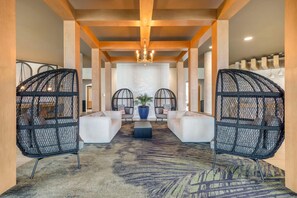 A lobby with a central seating area, a chandelier, and a patterned carpet. - Cambria Hotel Rehoboth Beach (Rehoboth Beach)