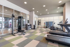A gym with treadmills, a weight machine, and a mirrored wall. - Cambria Hotel Rehoboth Beach (Rehoboth Beach)