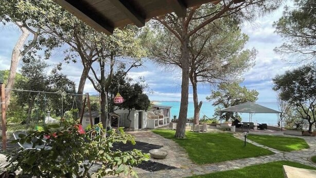 A patio area with a stone pathway, green lawn, and outdoor furniture. - Apartment in villa with direct access to the sea, suitable for families with children (Sas Linnas Siccas)