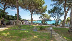 A courtyard with a stone pathway, a small garden area, and a view of the sea. - Apartment in villa with direct access to the sea, suitable for families with children (Sas Linnas Siccas)