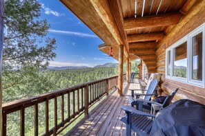 Eine Holzterrasse mit Blick auf Wald und Berge.