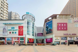 A commercial area with a NewMart store, a Rolex store, and a building with a large advertisement. - panjinxinsheng (Panjin)