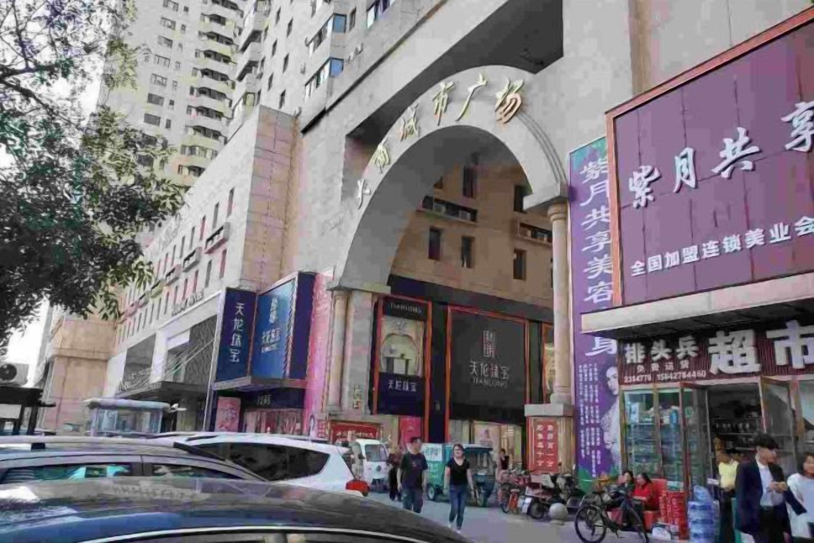 A commercial building with multiple storefronts, including a pharmacy and a market.