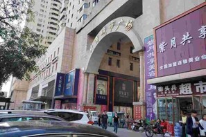 Un edificio commerciale con diverse vetrine, tra cui una farmacia e un mercato.