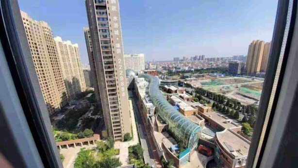 A high-rise building with a modern design, featuring a prominent vertical structure and a curved glass facade.