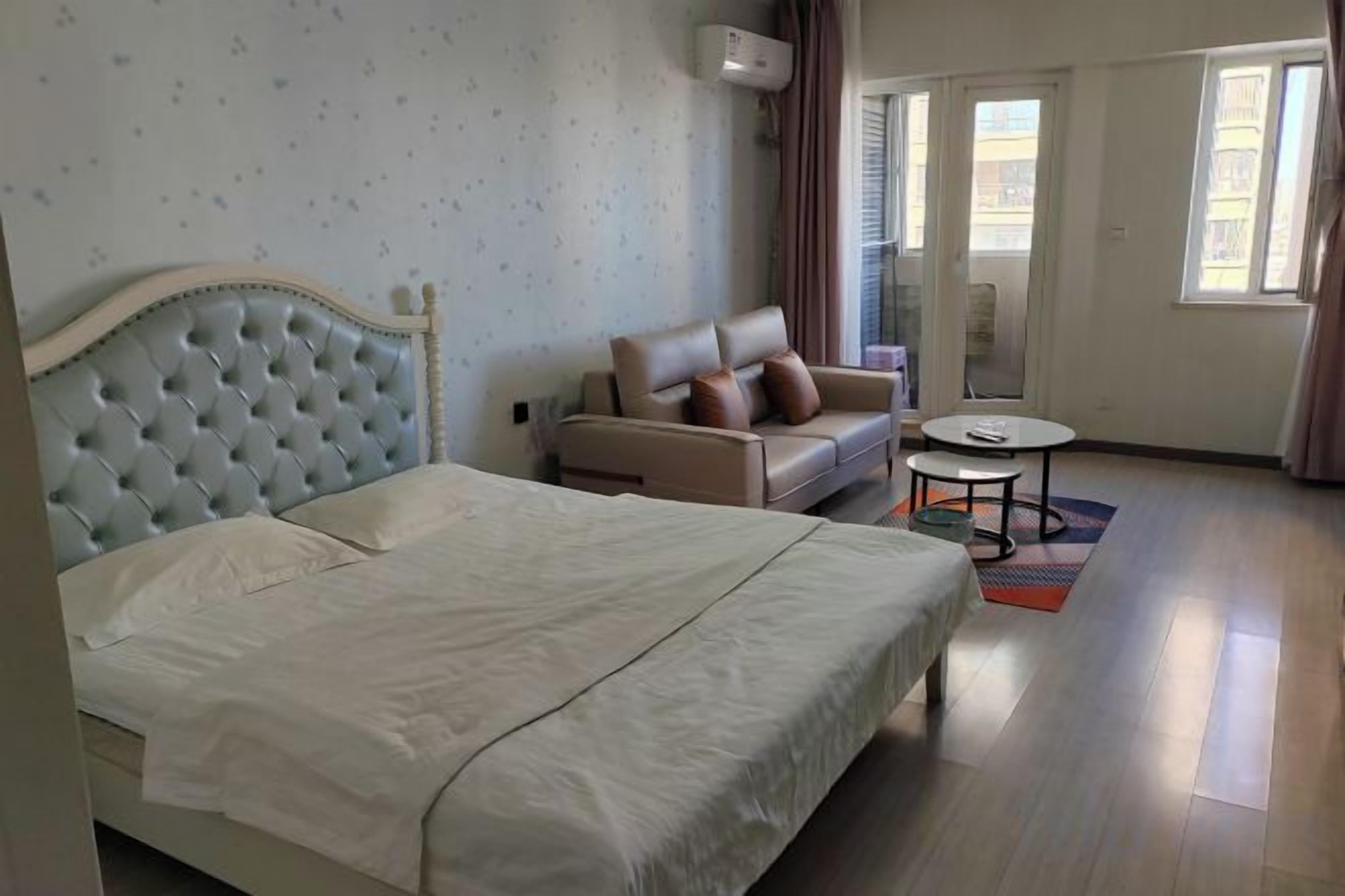 Une chambre d’hôtel avec un lit, un canapé, une petite table et une fenêtre.