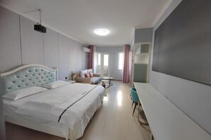 Ένα δωμάτι ο ξενοδοχείου με ένα κρεβάτι, έναν καναπέ, ένα μικρό τραπέζι και ένα γραφείο.