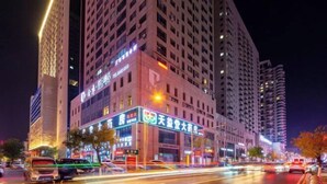 A multi-story hotel with illuminated signage and a modern facade.