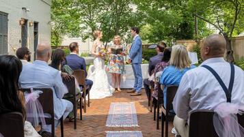 Une cérémonie de mariage en plein air, les invités étant assis sur des chaises disposées en rangées.