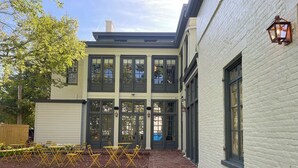 A two-story building with large windows and a brick pathway leading to the entrance. - The Ashbrook Hotel (Frankfort)