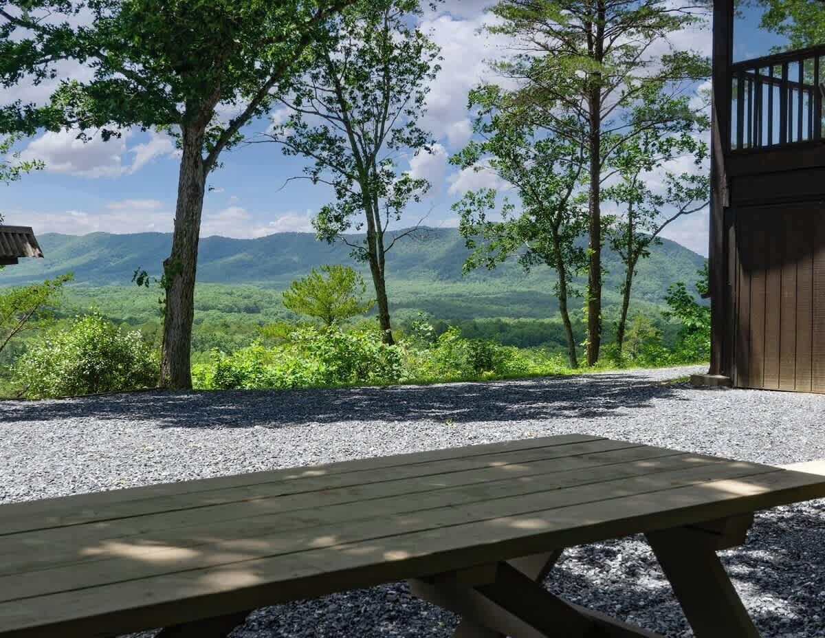 Ein Picknicktisch in einer natürlichen Umgebung mit Blick auf Berge und Bäume.
