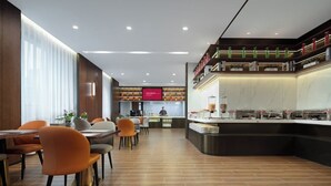 A modern restaurant with a long counter, multiple seating areas, and a visible kitchen area. - Mövenpick By Accor Binjiang Nanjing (Nanjing)
