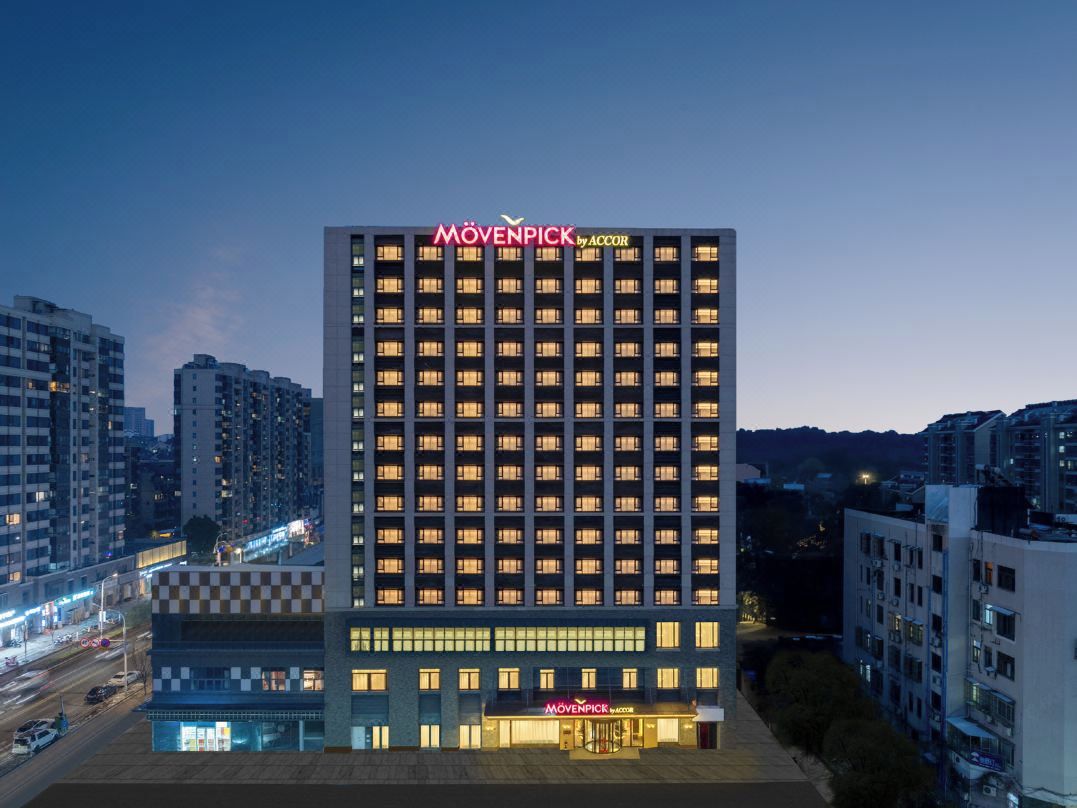 A high-rise hotel with a checkered facade, multiple floors, and a prominent brand name at the top.