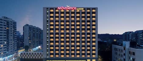 A high-rise hotel with a checkered facade, multiple floors, and a prominent brand name at the top.