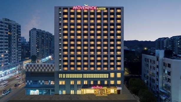 A high-rise hotel with a checkered facade, multiple floors, and a prominent brand name at the top. - Mövenpick By Accor Binjiang Nanjing (Nanjing)