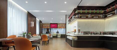 A modern restaurant with a long counter, multiple seating areas, and a visible kitchen area.