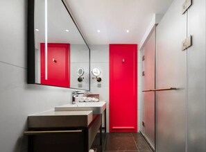 A modern bathroom with a white sink, two mirrors, and a red door. - Mövenpick By Accor Binjiang Nanjing (Nanjing)