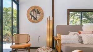 Ein modernes Wohnzimmer mit einer Couch, einem Sessel und einer Wanddekoration.