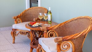 A wicker table with two chairs, a bottle of white wine, and a plate with food. - Villa with Jacuzzi and Heatable Pool (Armação de Pêra)