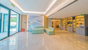 A modern lobby with a seating area, a glass wall with a view, and a well-lit interior. - GreenTree Inn Express Hotel (Beijing)