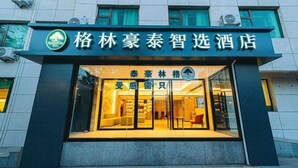 A hotel entrance with a modern design, featuring a glass facade and a welcoming interior. - GreenTree Inn Express Hotel (Beijing)