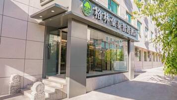 A building with a modern facade, a visible entrance, and a sign with Chinese characters.