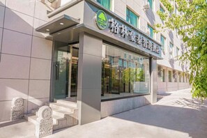A building with a modern facade, a visible entrance, and a sign with Chinese characters. - GreenTree Inn Express Hotel (Beijing)