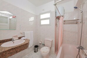 A bathroom with a sink, toilet, and bathtub.