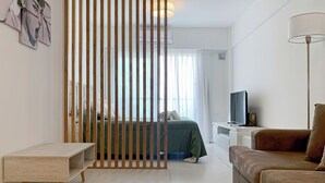 Ein modernes Hotelzimmer mit Bett, Schreibtisch, Fernseher und Sofa.
