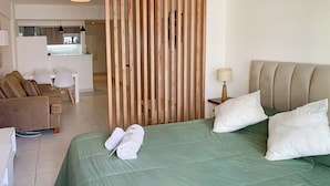 Ein Hotelzimmer mit Bett, Sofa, Schreibtisch und einer Holzwand.