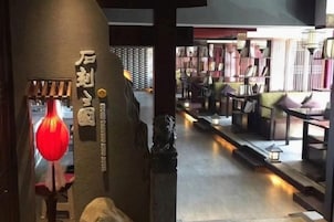 Un interior con una estantería, una lámpara colgante roja y una escalera.