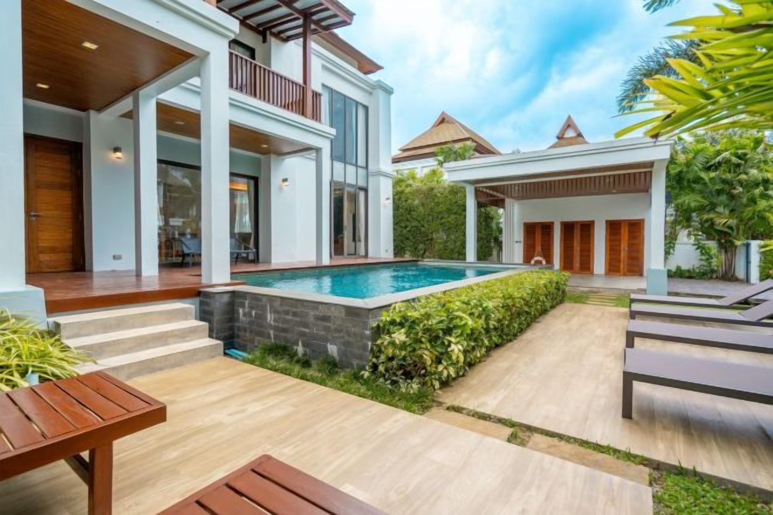 Una casa moderna con piscina, mobiliario de exterior y un patio cubierto.