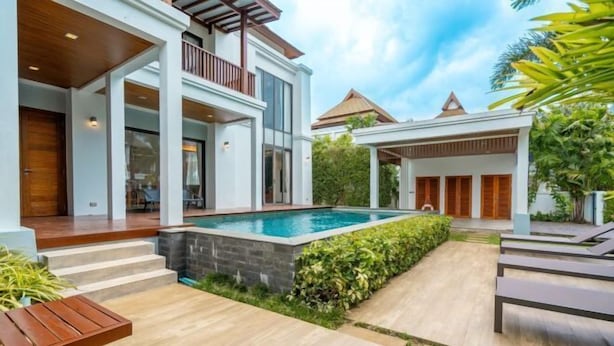 Une maison moderne dotée d’une piscine, d’un espace extérieur aménagé et d’un jardin bien entretenu.