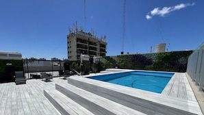 A rooftop pool with wooden decking and lounge chairs. - Beautiful Apartment for 4 pax in Caballito With Pool (Buenos Aires)