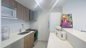 A modern kitchen with a microwave, stove, sink, and coffee maker. - Beautiful Apartment for 4 pax in Caballito With Pool (Buenos Aires)
