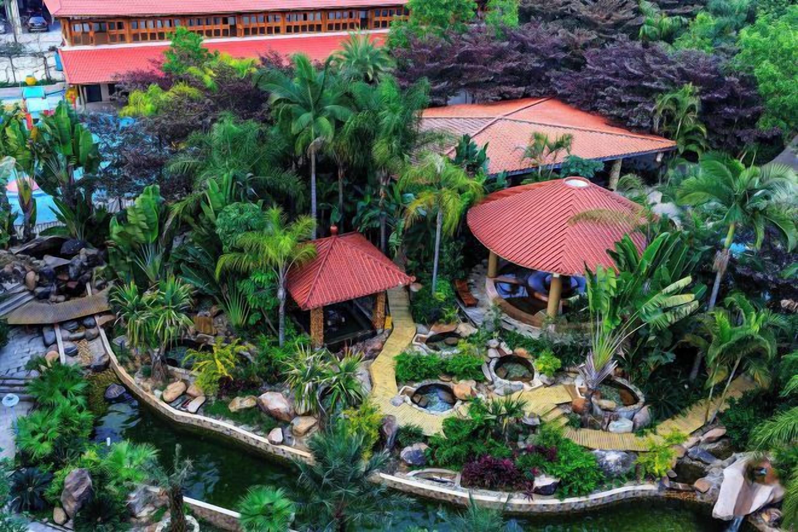 Un complexe hôtelier tropical doté d’un espace aquatique central, de zones de repos abritées et d’une végétation luxuriante.