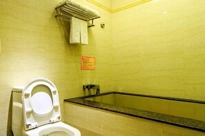 Une salle de bain avec des toilettes, un lavabo et une baignoire.