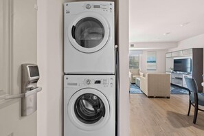 Een moderne wasruimte met twee gestapelde wasmachines, een digitaal bedieningspaneel en een ingebouwde droger.