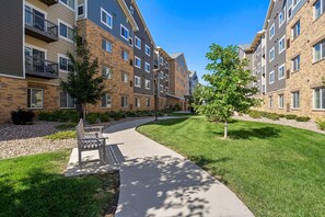 A residential building with multiple floors, balconies, and a well-maintained lawn. - Waterwalk Extended Stay Kansas City - Overland Pk (Overland Park)
