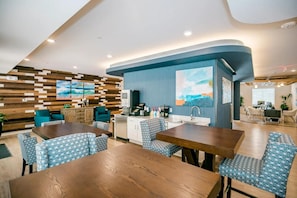A modern hotel room with a wooden wall, a kitchen area, and a seating area with patterned chairs. - Waterwalk Extended Stay Kansas City - Overland Pk (Overland Park)