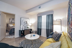 A modern living room with a sofa, coffee table, and artwork on the walls. - Waterwalk Extended Stay Kansas City - Overland Pk (Overland Park)
