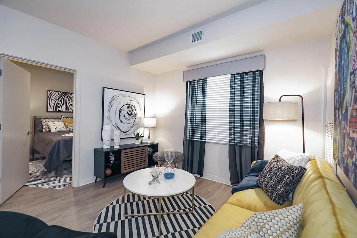 A modern living room with a sofa, coffee table, and artwork on the walls.